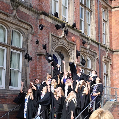 Uni of Sheffield Students throwing graduation caps into the air